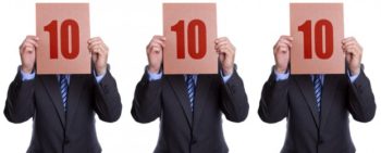 Three men in suites each holding up the number 10 indicating a perfect 10 score