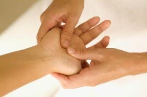 person performing acupressure on hand