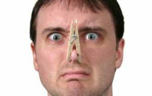 Man wearing clothes pin on nose because smelly